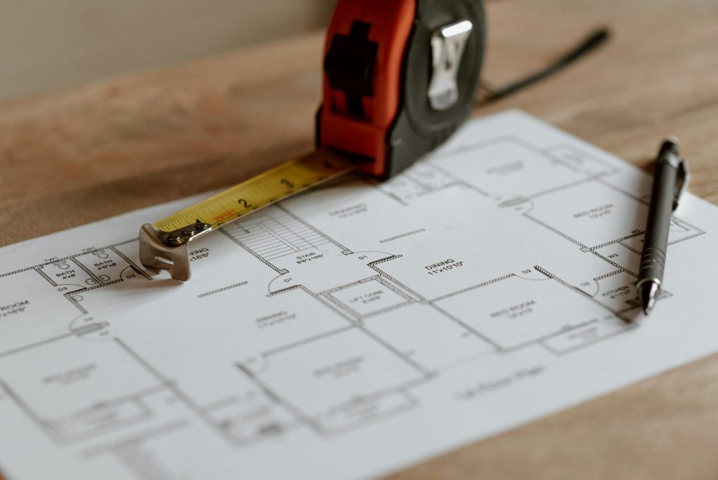 Vue de dessus de la règle placée près du crayon sur le plan d'ingénierie de la maison pendant le processus de rénovation