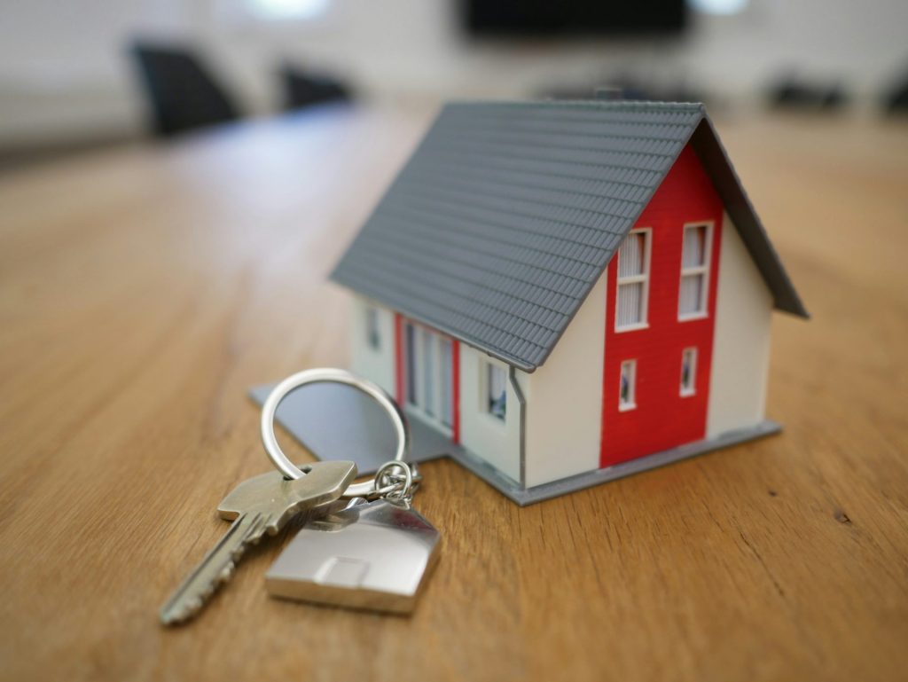 Maison miniature en bois blanc et rouge sur une table marron